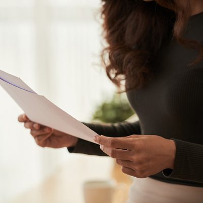 Cropped image of business woman reading documents in her hands